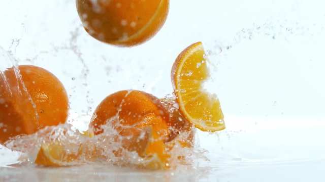 Super slow motion of falling pieces of oranges, isolated on white background. Filmed on high speed cinema camera, 1000 fps.