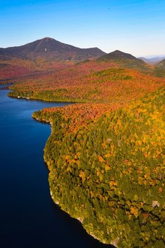 Fall colors surround a lake in New England - aerial