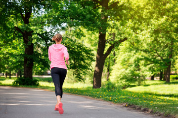 Fitness woman training and jogging in summer park