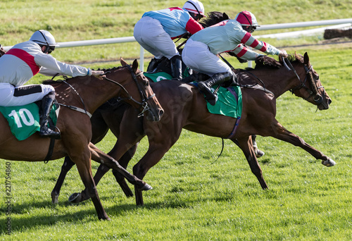 Galloping Race Horses And Jockeys Competing On The Track