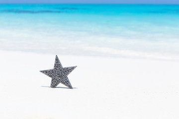 Fototapeta na wymiar Stars decorations on sandy beach, greeting card