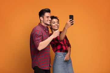 Mixed race couple taking selfie.
