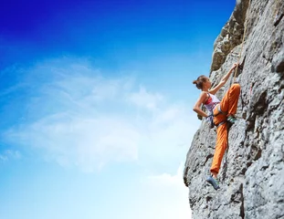 Gardinen young slim female rock climber climbing on the cliff © vitaliymateha