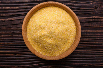 raw Italian corn porridge polenta on a rustic wooden background