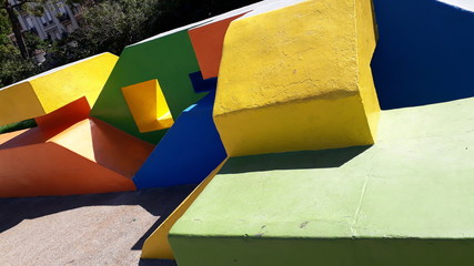 Construction of cement with colorful geometric shapes in a playground for jumping.