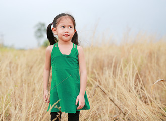 Cute little child girl relaxing in summer field outdoor. Freedom style.