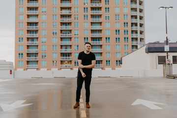 Young Trendy Male Fashion Model in Denim Jacket on Top of a Downtown Parking Garage