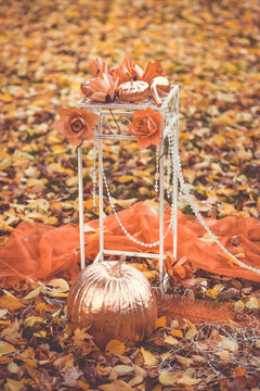 Golden pumpkin as decoration on the green and yellow leaves