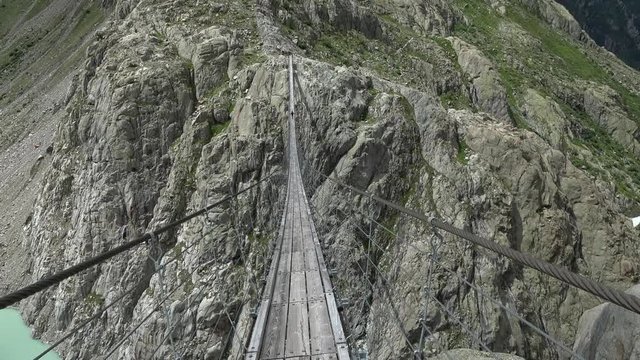 Walk through Trift Bridge, around lake, glacier and mountains, national park Switzerland, Europe. Summer landscape, sunshine weather and sunny day