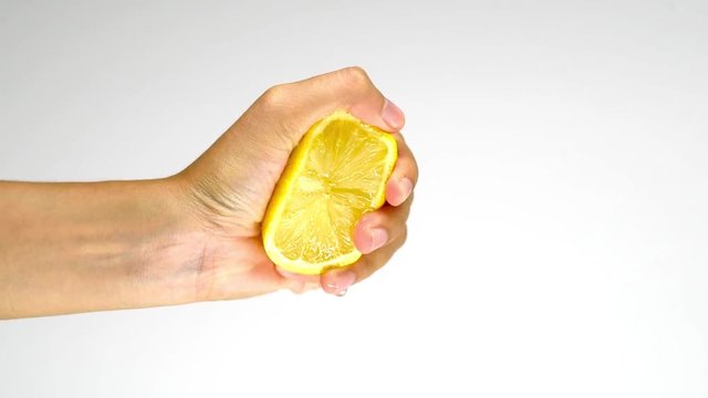 woman squeezing half of lemon isolated on white background in the studio