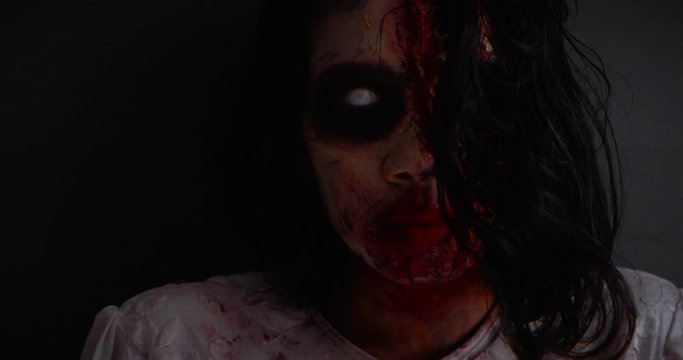 Slow motion of scary face of ghost girl staring at the camera in dark night. Halloween concept. Shot in 4k resolution