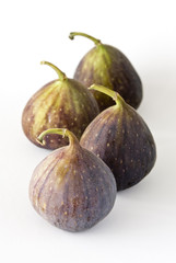 Four fig fruits on a white background.