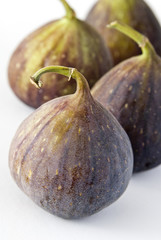 Four fig fruits on a white background.