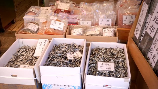 boxes of tiny dried fish and bgs of dried seafood for sale at tsukiji fish market in tokyo, japan