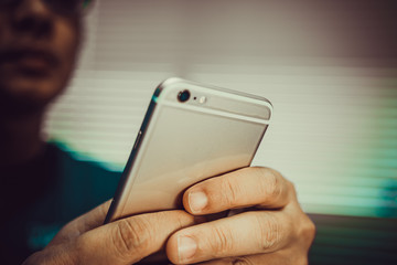 Man playing smart phone on handheld in office