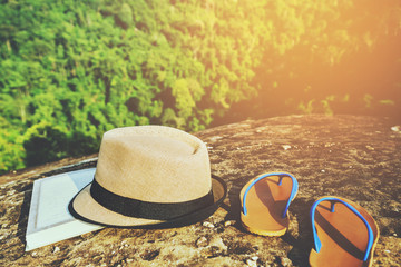 travel nature, Travel relax, A hat book with slippers rests on the rocks on the cliff.
