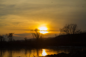 Bright Orange Sunset Over Calm River 