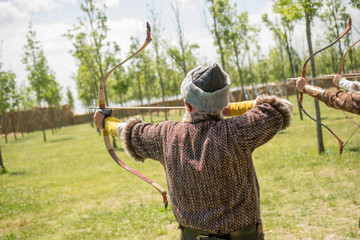 Archer in traditional clothes shooting an arrow
