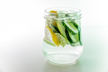 Summer drink coctail in glass jar, berries and mint on wooden table