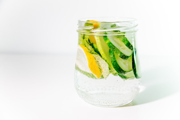 Summer drink coctail in glass jar, berries and mint on wooden table