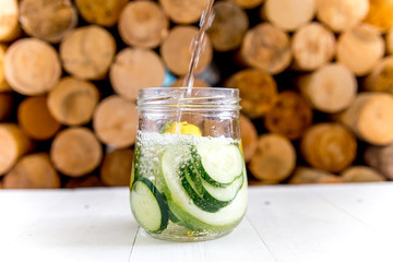 Summer drink coctail in glass jar, berries and mint on wooden table