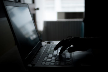finger press button on laptop keyboard in the dark tone