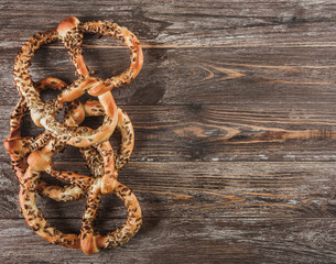 Top view of three pretzels with sunflower seeds on wooden background. Copy space