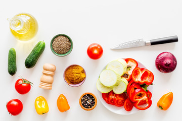 Vegetarian food concept. Set of vegetables for stew. Squash, bell pepper, tomato, spices, oil on white background top view copy space