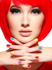 beautiful face of a girl with stylish multicolor nails.