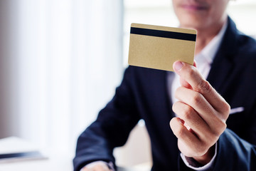 Businessman holding gold credit card.