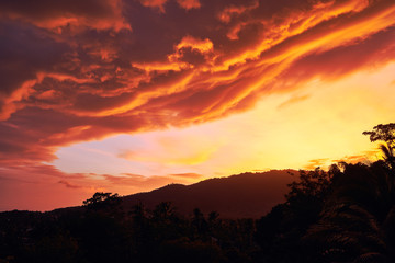 Dramatic clouds against the backdrop of mountains at sunset on a tropical island. 4k time lapse
