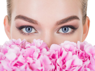 Young beautiful woman with flowers near face.