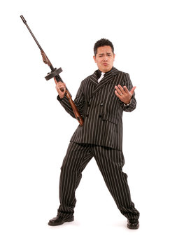 A 1940's styled adult male mafia gangster character wearing a black seersucker suit and holding a machine gun.