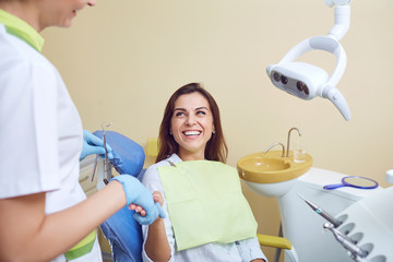 A young woman is shaking hands with a dentist in a dental clinic.