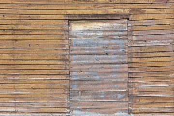 background of faded brown old wooden wall with boarded up window 