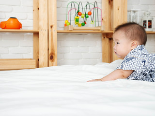 Asian baby boy crawl  on the bedroom.