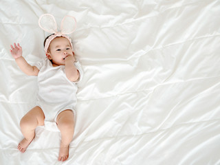 Asian baby girl lying on bedroom.