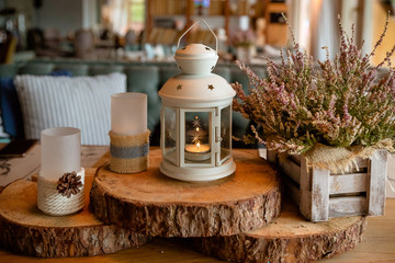White burning lantern, heather in wooden box on a wooden table decorated in autumnal style, pine...