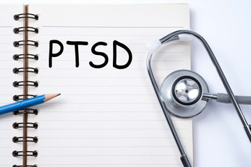 Stethoscope on notebook and pencil with PTSD - post traumatic stress disorder words. Medical concept. War veteran mental health issue.