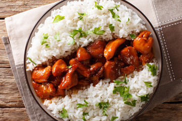 Louisiana food: bourbon chicken with garnish of rice close-up served on a plate. horizontal top...