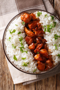 American food: Bourbon chicken in a sauce with whiskey, served with rice on a plate. Vertical top view