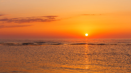 Baltic sea - early morning golden sunrise over the sea. Fishing boats on the sea against the background of sunrise and sunlight. Kurzeme, Latvia