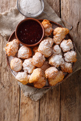 Albanian traditional food: fried dough petulla with raspberry jam and powdered sugar close-up. Vertical top view