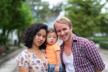 Fototapeta na wymiar Portrait of happy multi-ethnic family bonding together outdoors