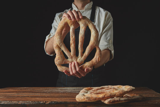 Baker's hands hold fougas bread