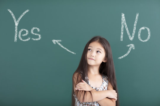 beautiful little girl thinking before chalkboard