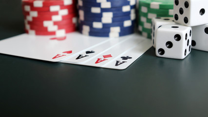 Casino chips with cards and dice on the dark green background.