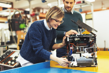 Young attractive students of mechatronics working on project