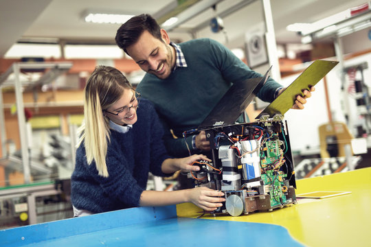 Young Attractive Students Of Mechatronics Working On Project