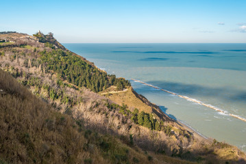 Fototapeta na wymiar Coastline along the mount San Bartolo, near Pesaro; the village Fiorenzuola di Focara in the background